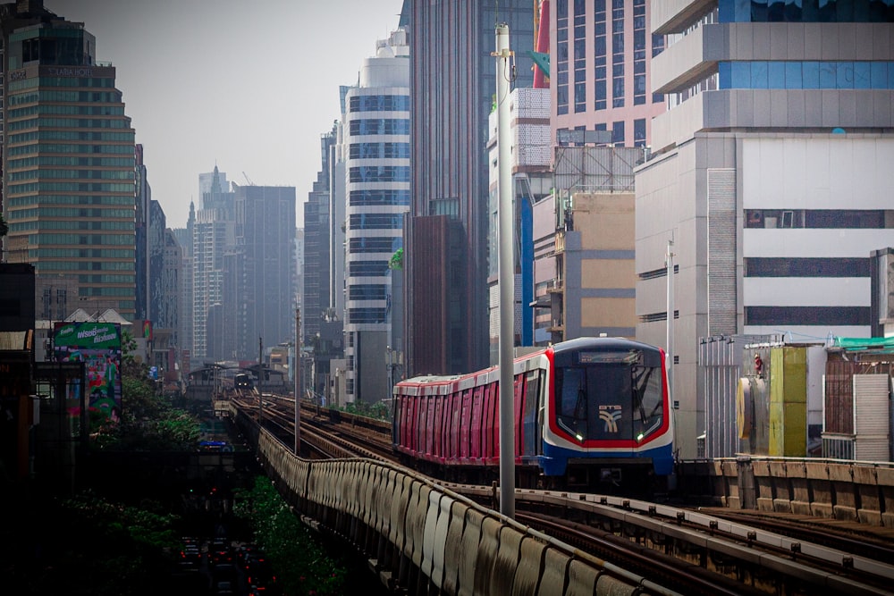 a train traveling through a city next to tall buildings