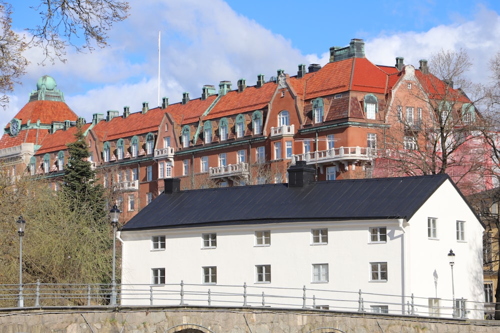 a white building with a black roof next to a bridge