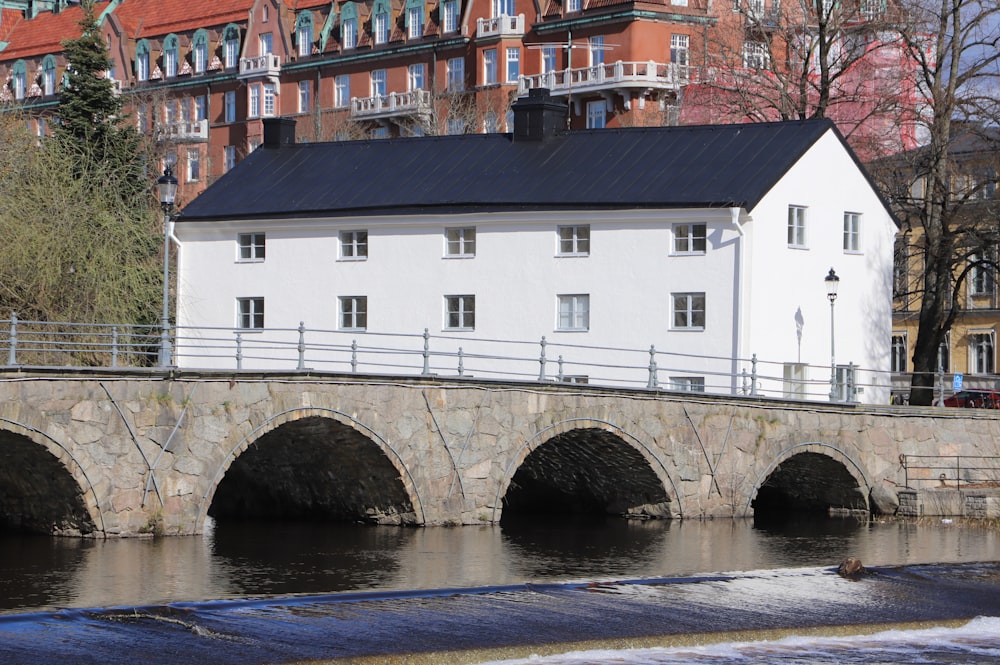 a bridge over a body of water with a building in the background