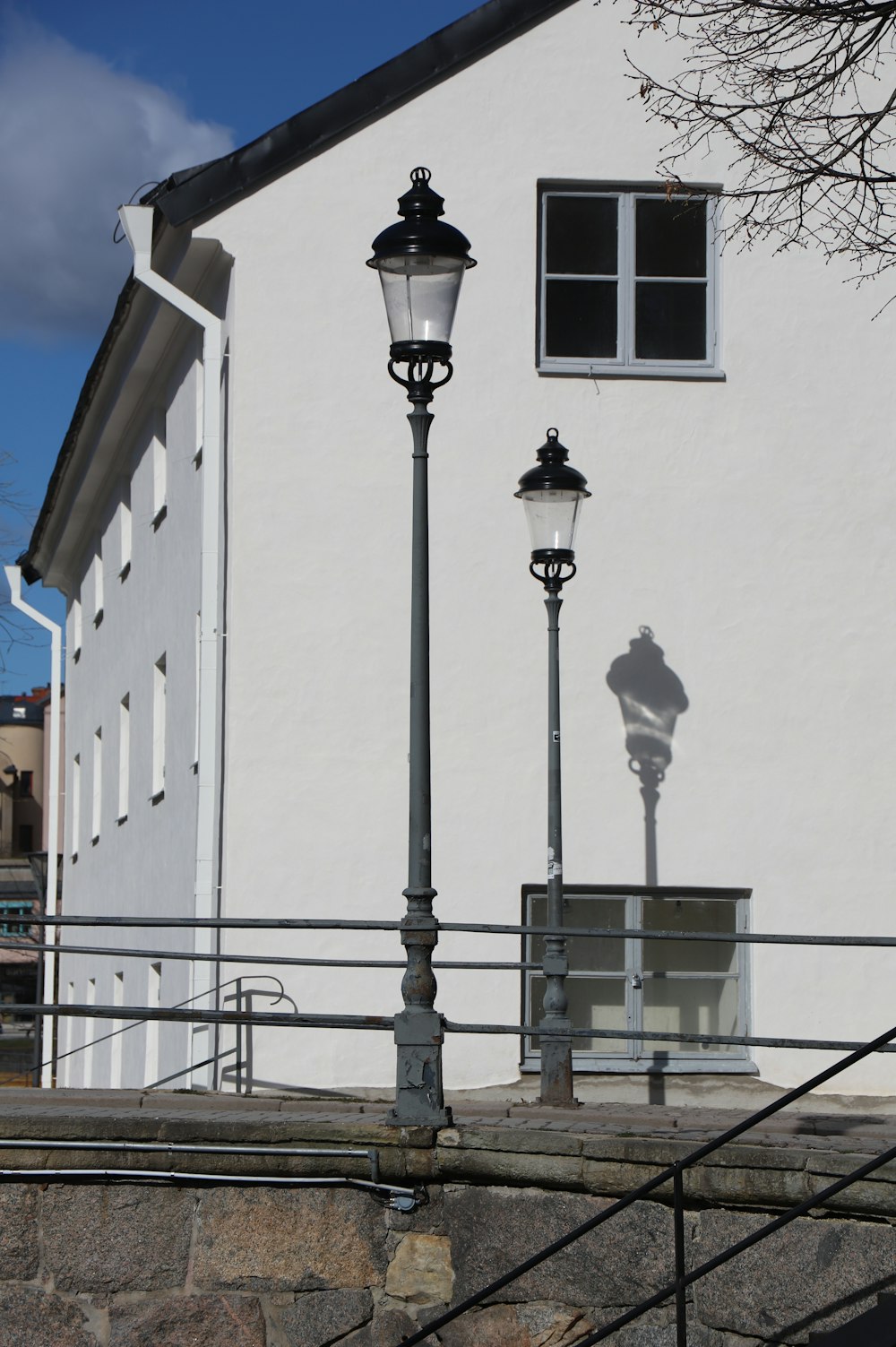 a white building with a lamp post next to it