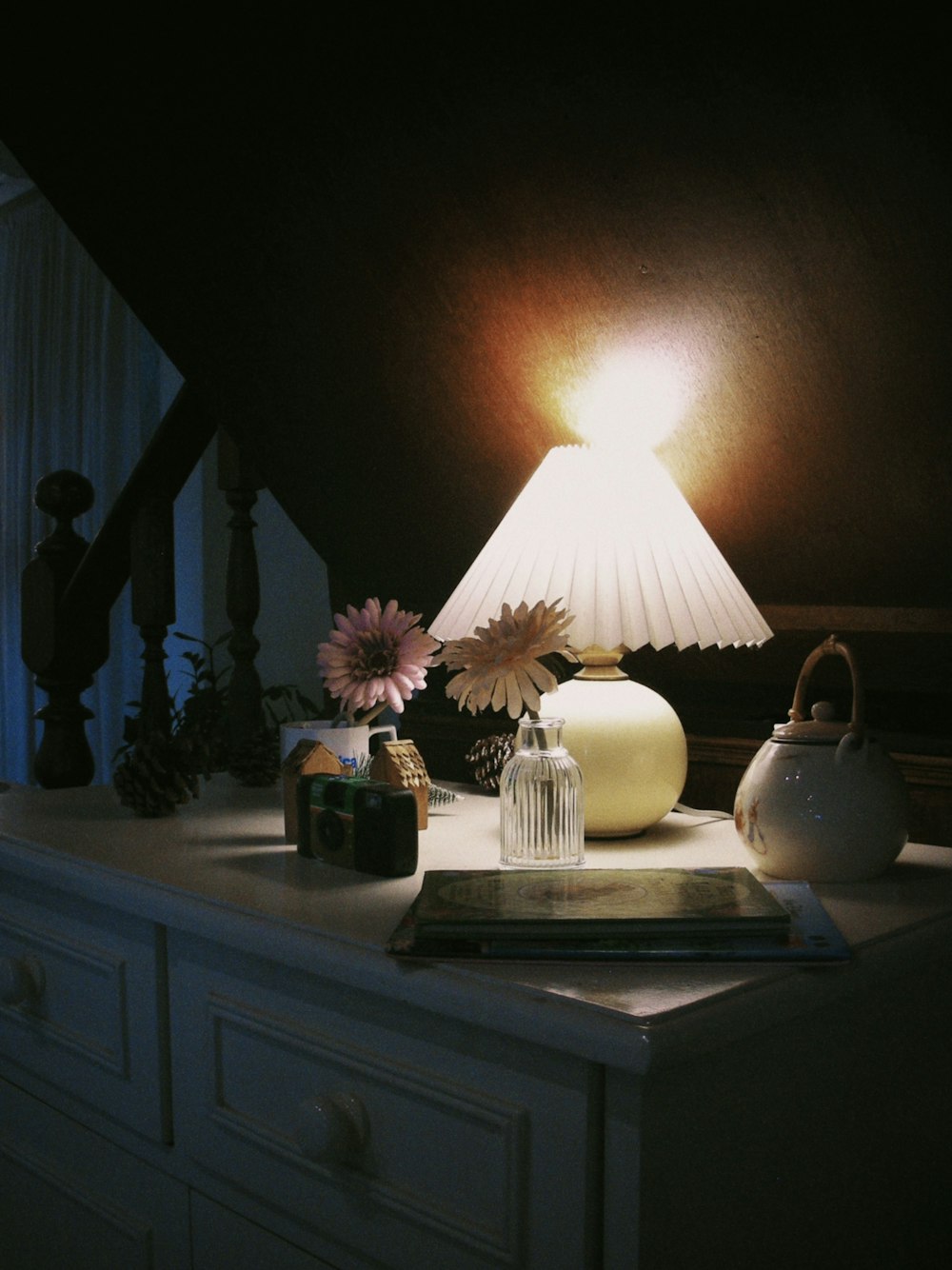 a lamp sitting on top of a white dresser