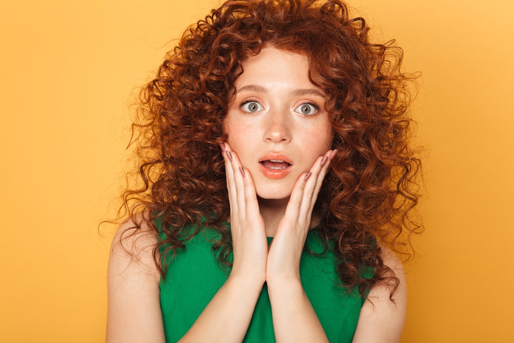 a woman with red curly hair posing for a picture