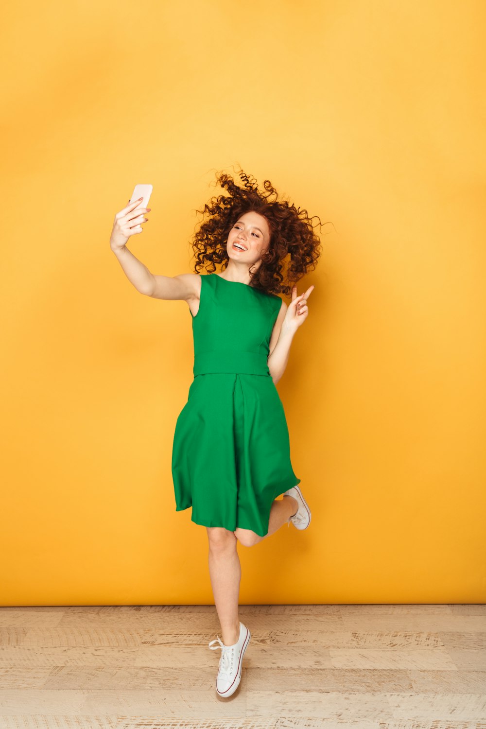 Eine Frau in einem grünen Kleid springt in die Luft