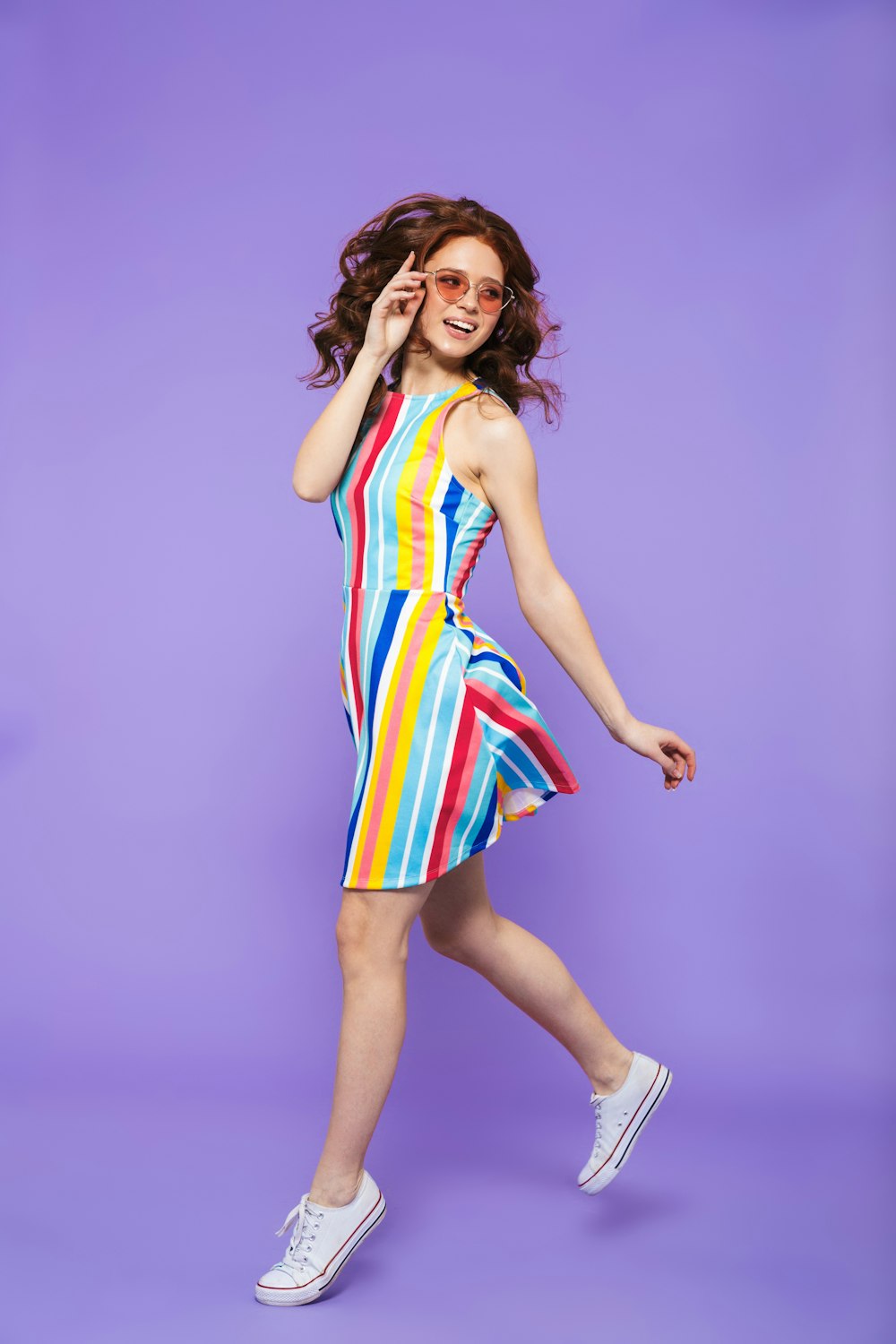 a woman in a colorful dress is posing for a picture