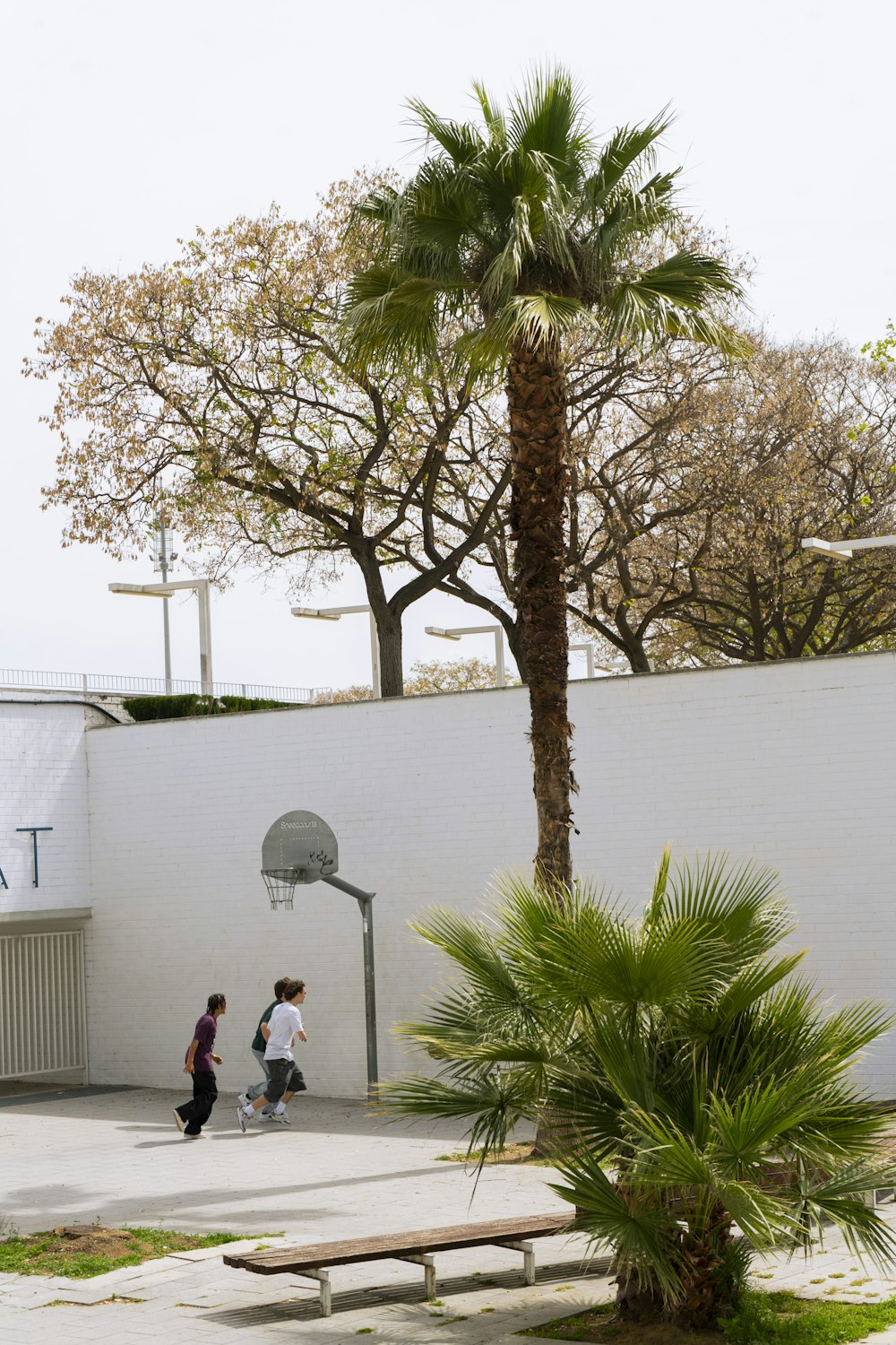 a couple of people walking past a basketball court