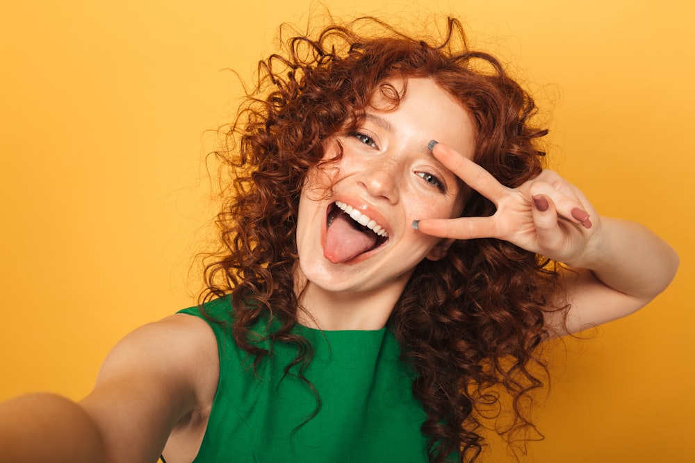 a woman making a peace sign with her fingers