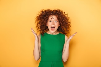a woman in a green dress making a surprised face