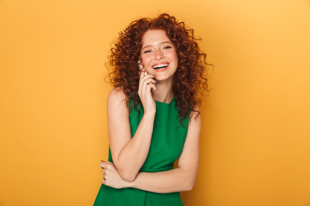 a woman in a green dress is smiling