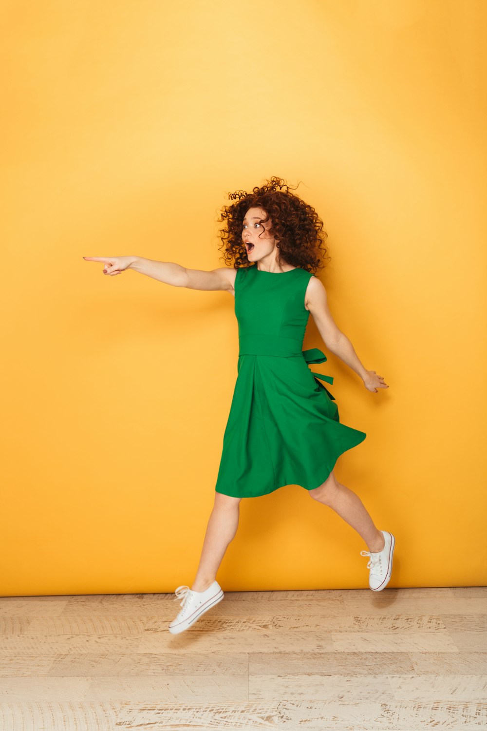 a woman in a green dress is dancing