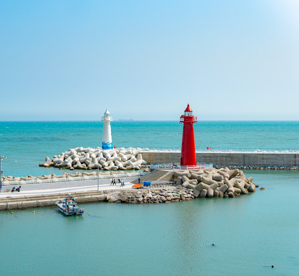 a red and white light house sitting on top of a pier