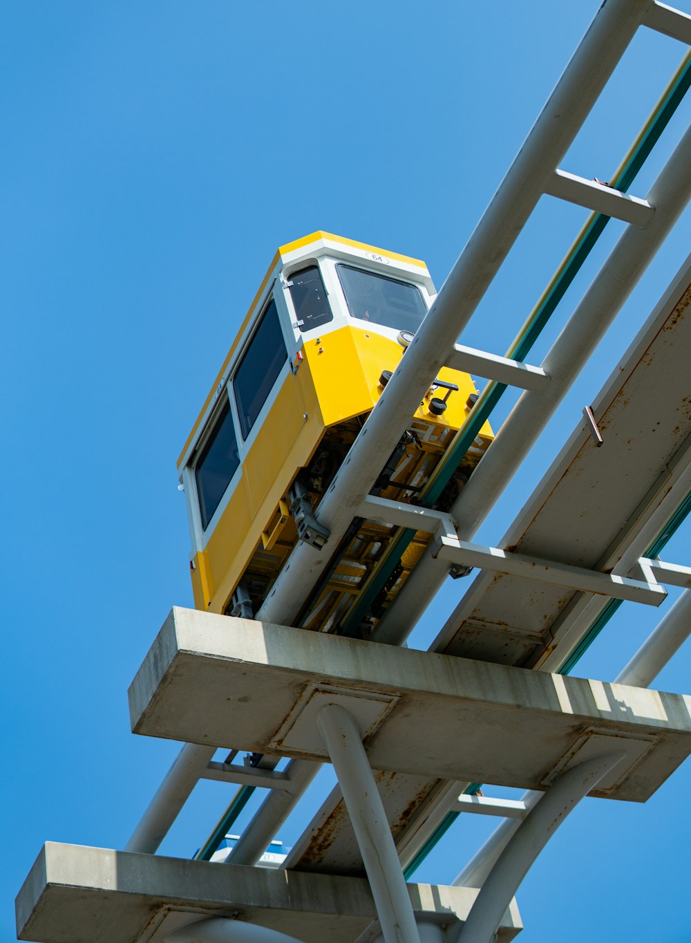 a yellow and white train traveling over a bridge