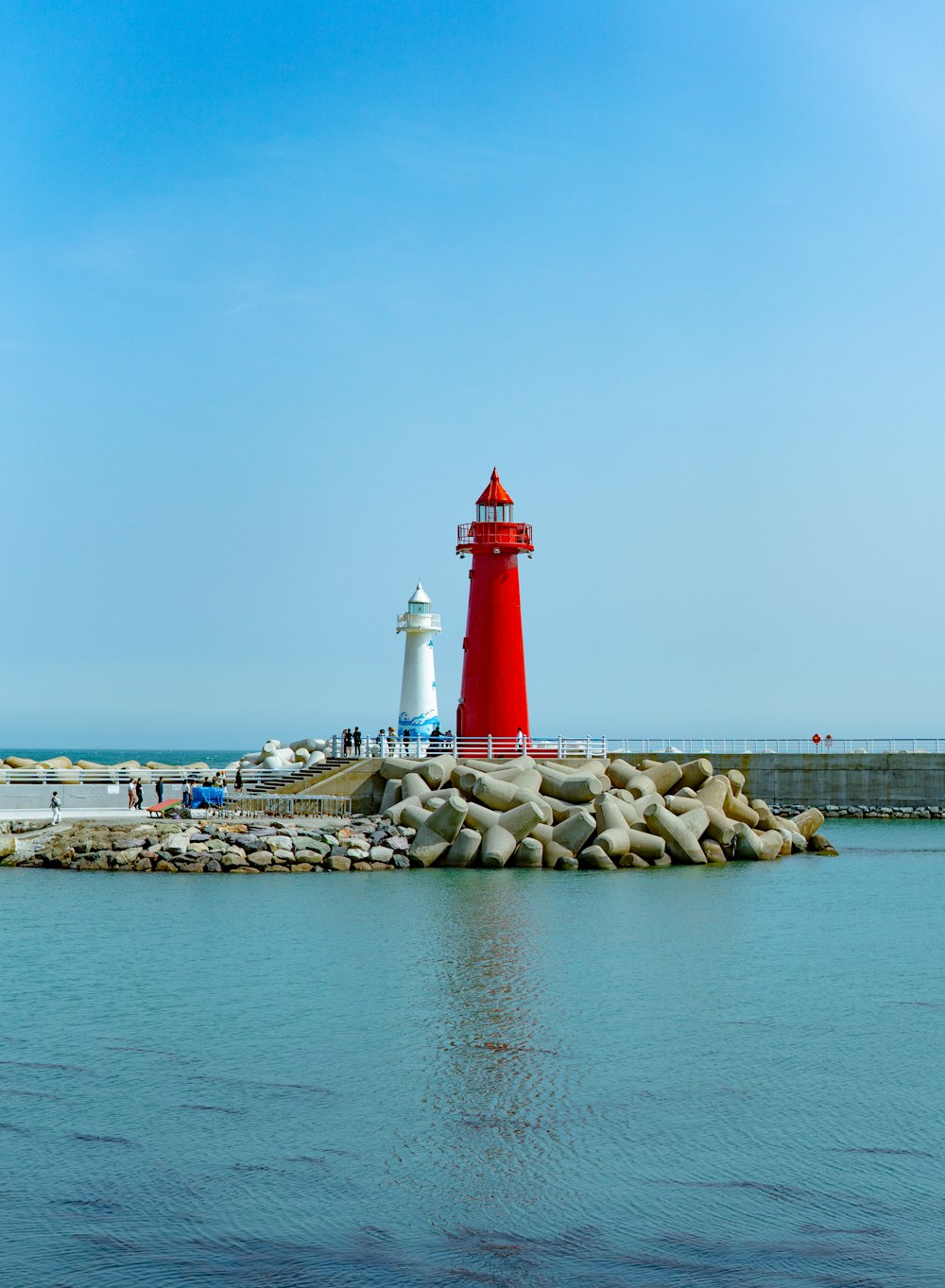 a red and white light house sitting on top of a pier