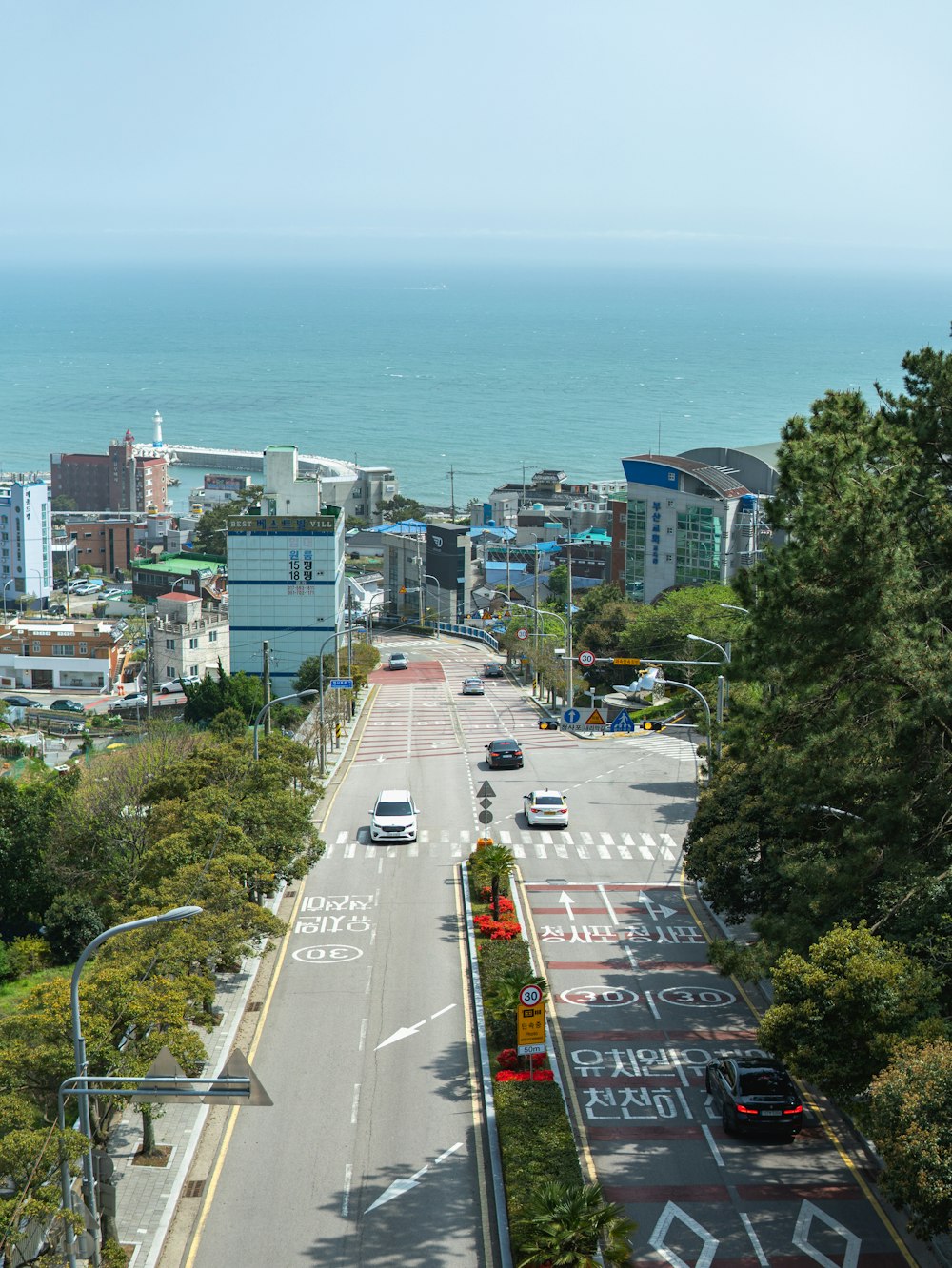 a view of a city street with a large body of water in the background