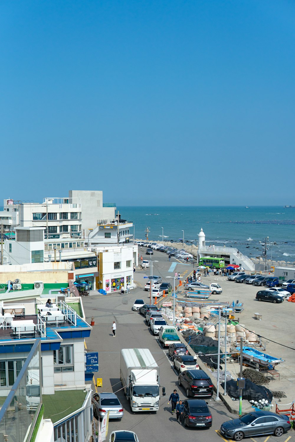 a parking lot filled with lots of cars next to the ocean