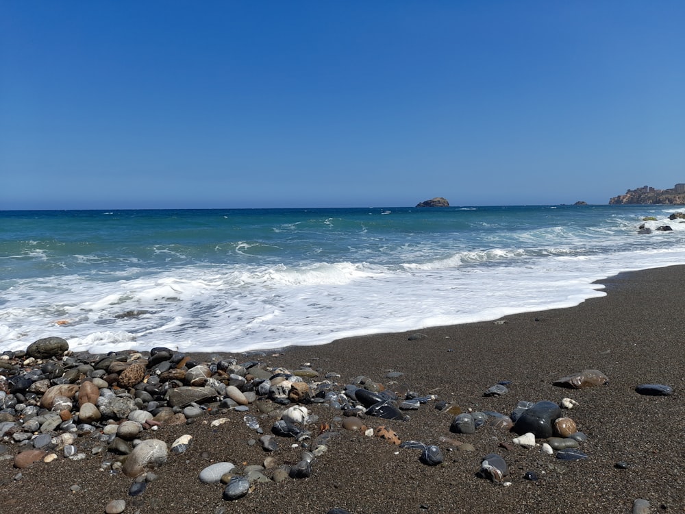 a rocky beach with waves coming in to shore