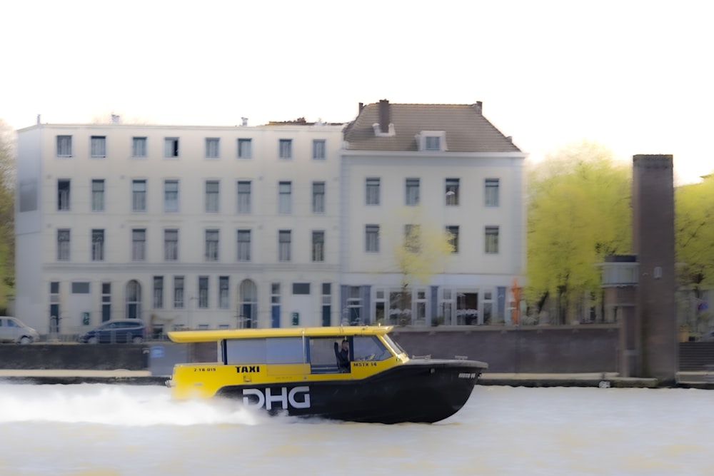 a yellow and black boat traveling down a river
