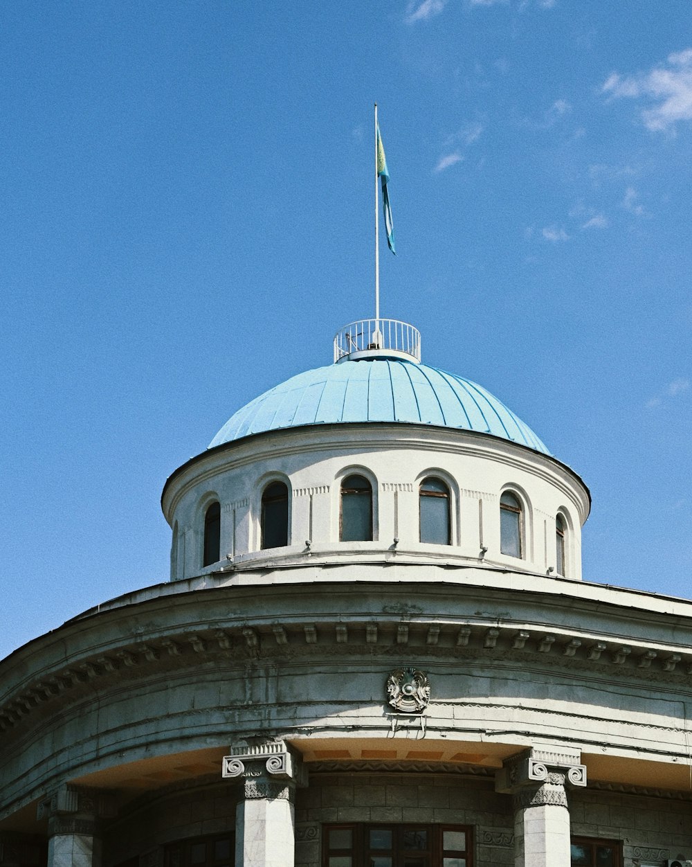 a white building with a blue roof and a flag on top