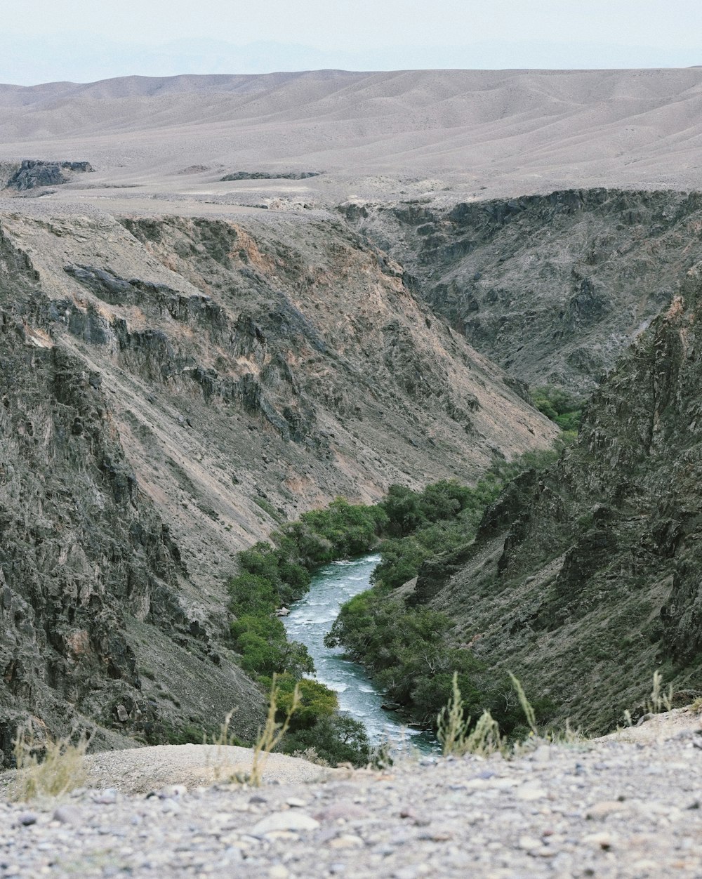 a river running through a valley surrounded by mountains