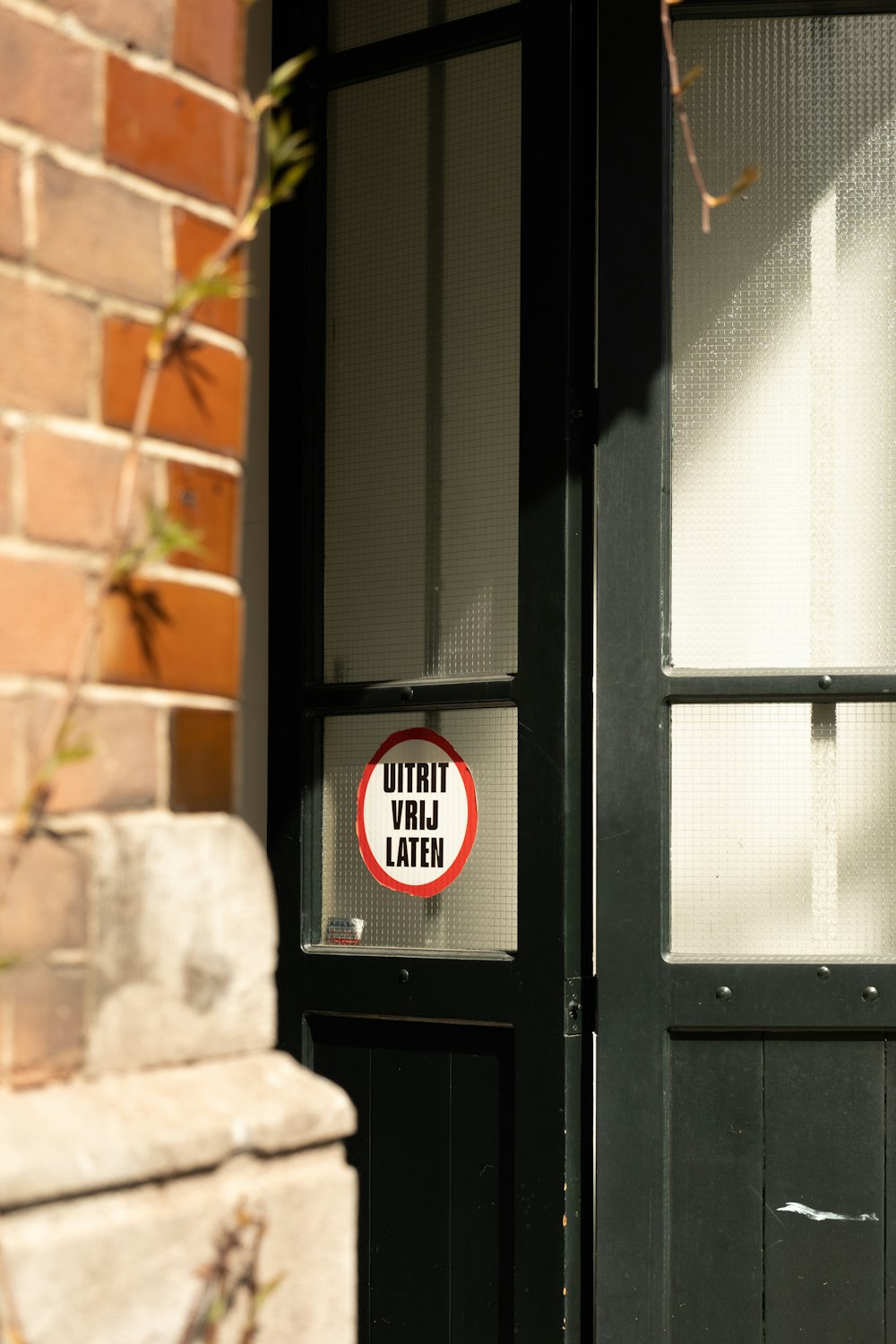 a red and white sign on a black door