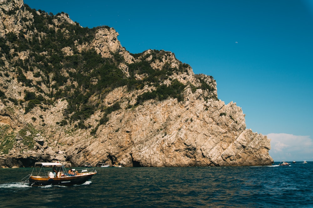 a small boat in a body of water near a mountain