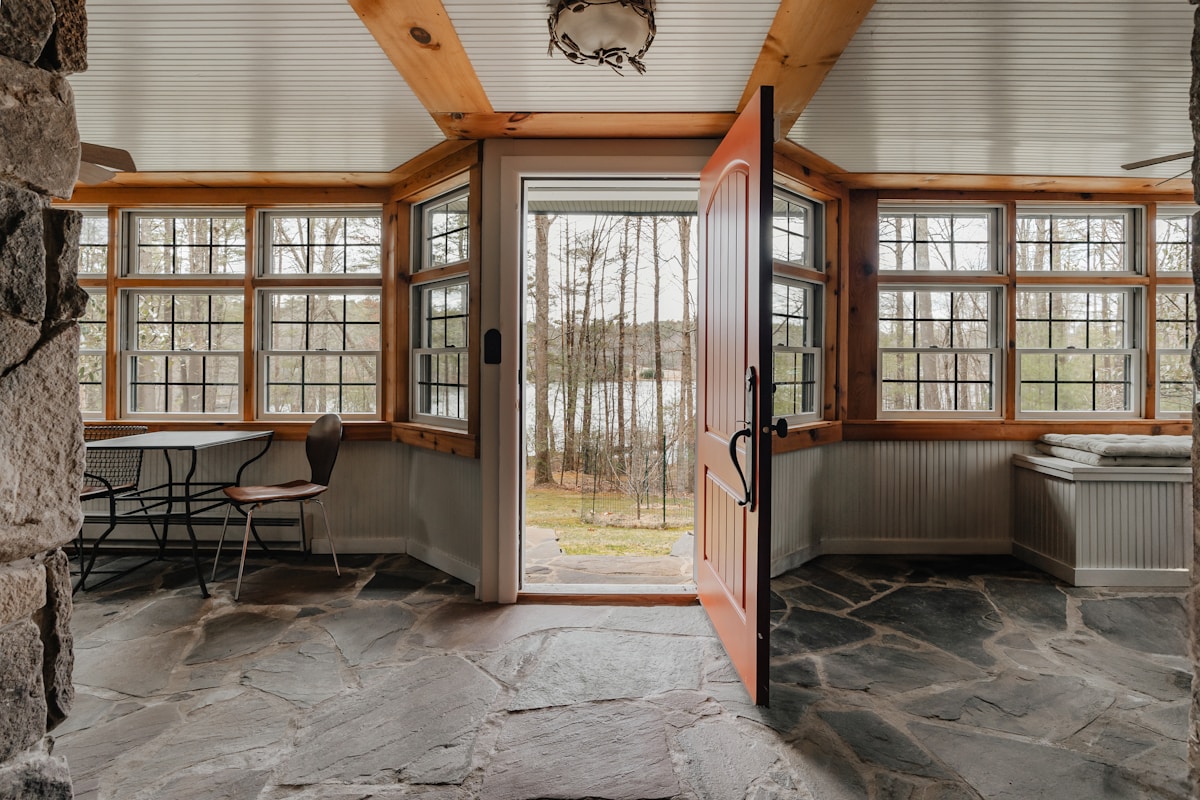 Interior of a stone building with rough stacked stone walls and a flagstone floor in warm light