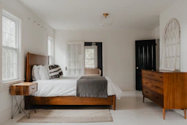 a bed room with a neatly made bed and a dresser