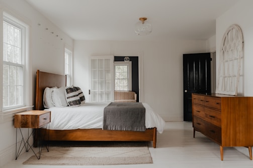 a bed room with a neatly made bed and a dresser