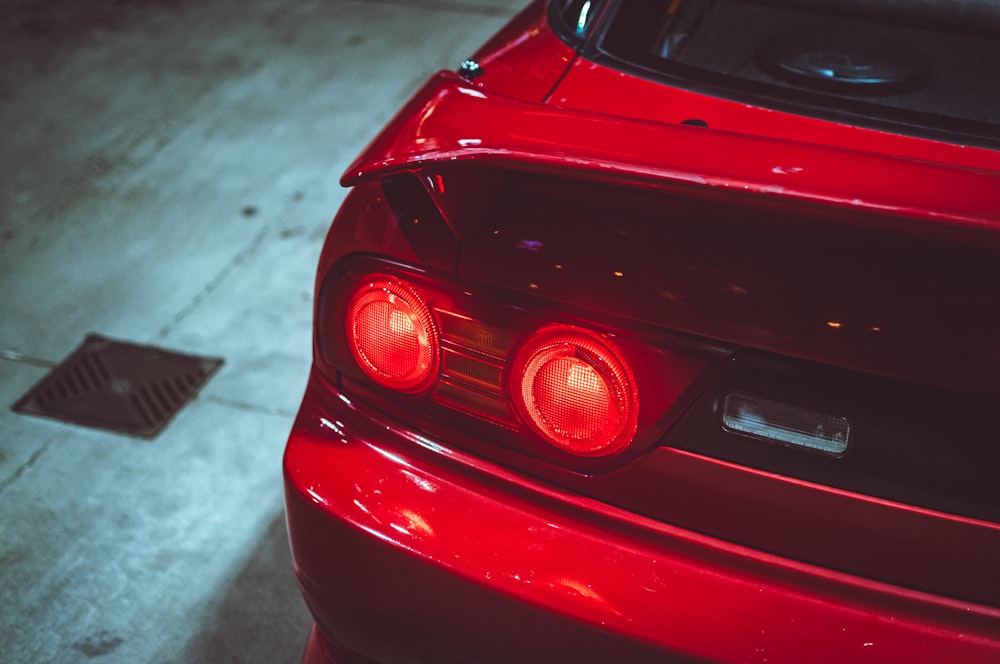 a close up of the tail lights of a red sports car