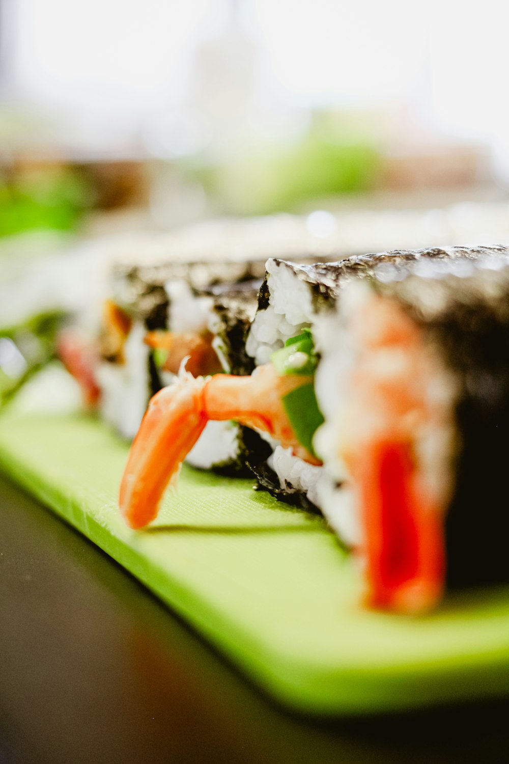 un gros plan de sushi sur une planche à découper verte