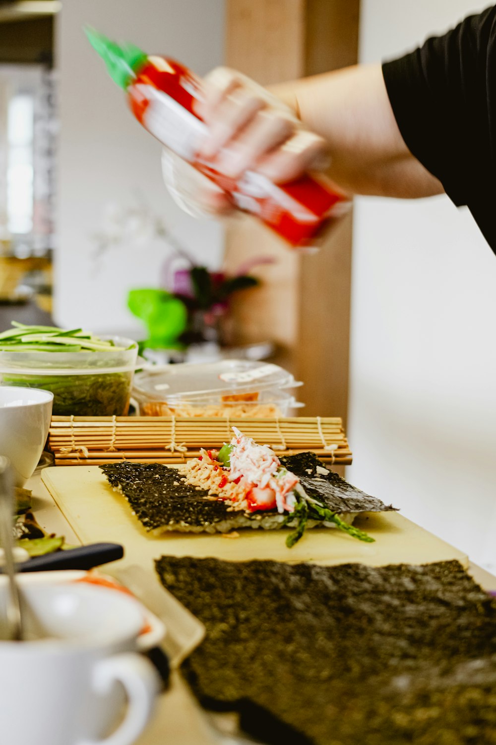 a person pouring something into a cup on a table