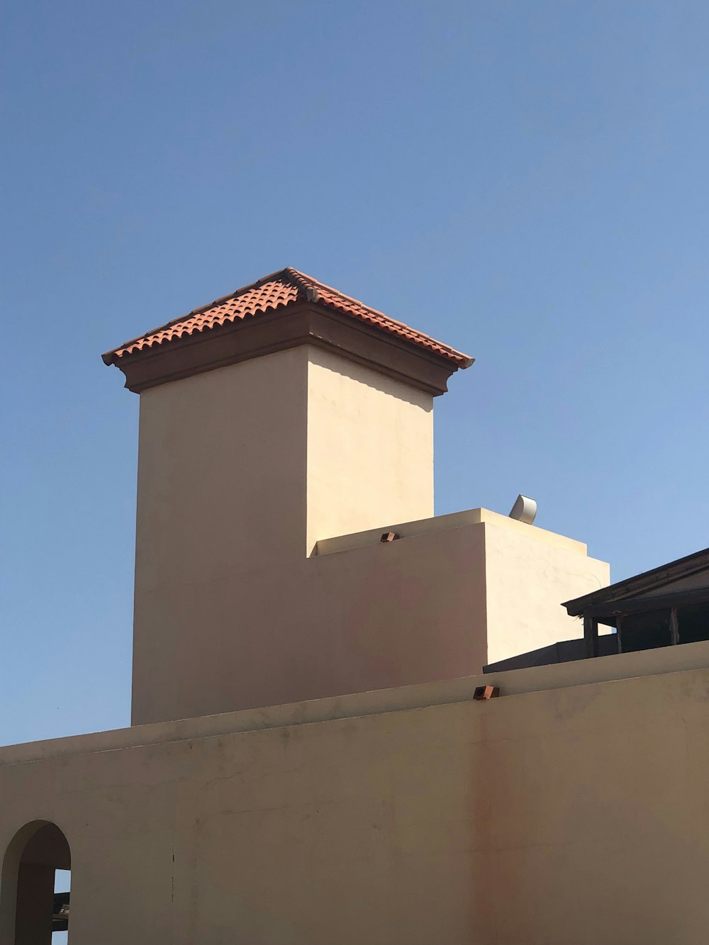 a tan building with a red tiled roof