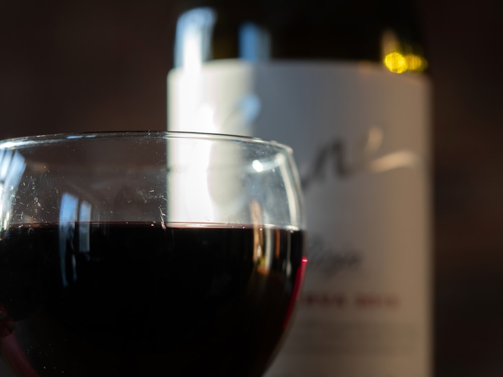 una copa de vino junto a una botella de vino