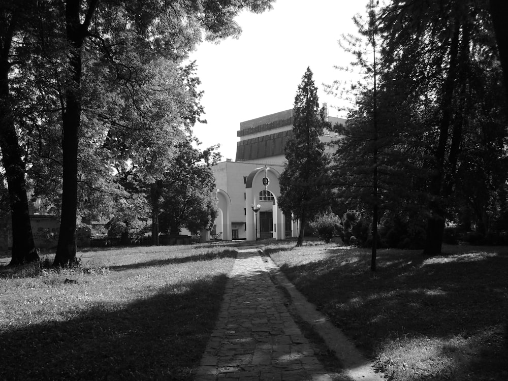 a black and white photo of a church surrounded by trees