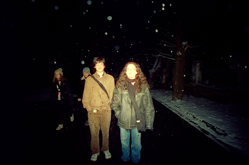 two people standing in the snow at night