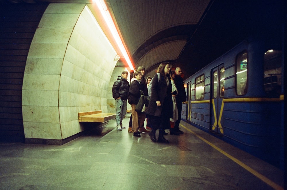 a group of people standing on a subway platform