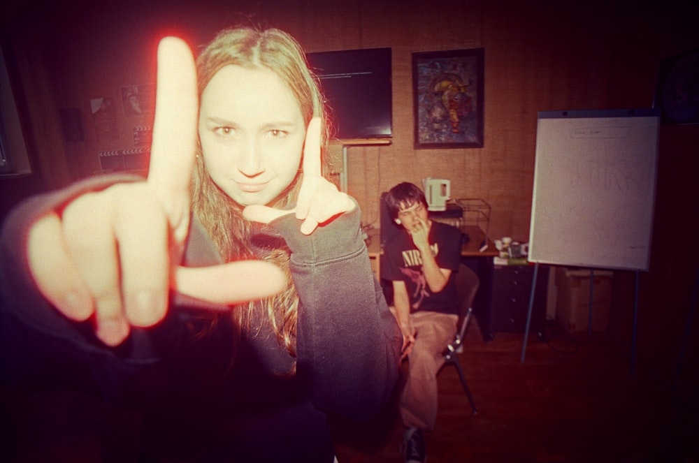 a woman making a peace sign with her fingers