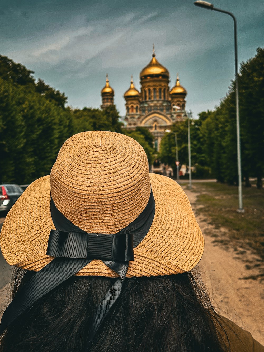 a woman wearing a straw hat with a black bow