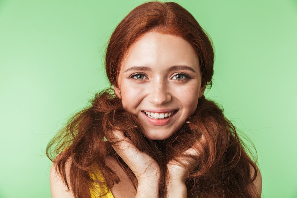 a woman with long red hair posing for a picture