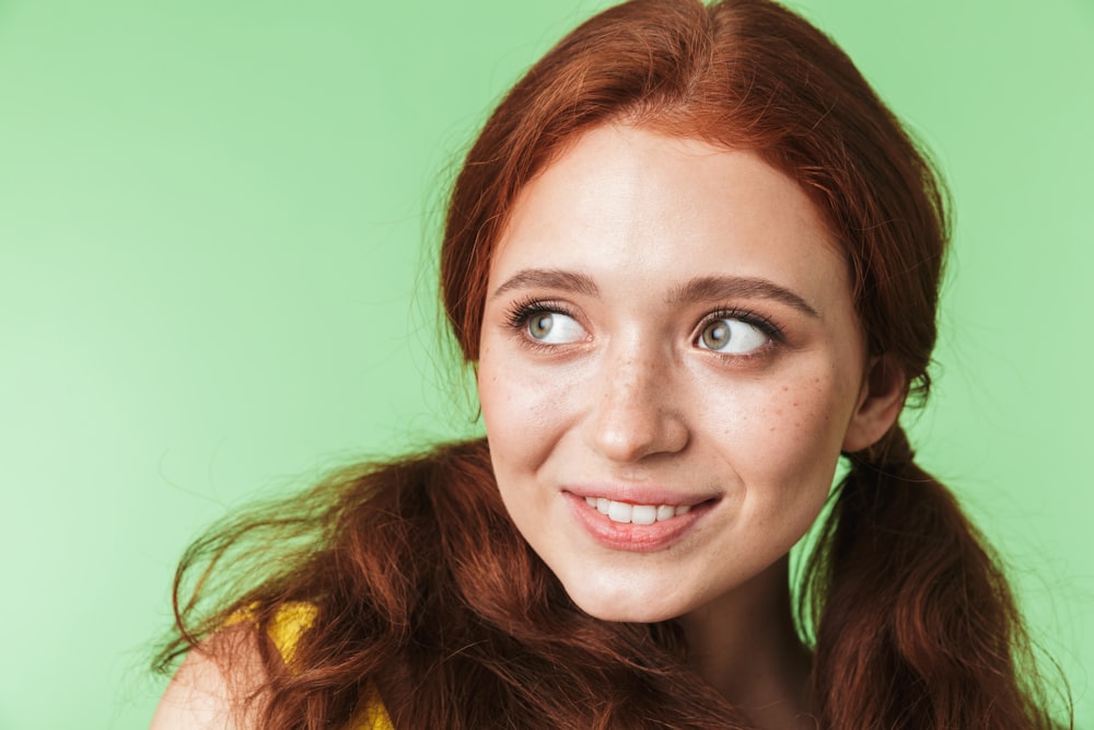 a woman with long red hair and a smile on her face