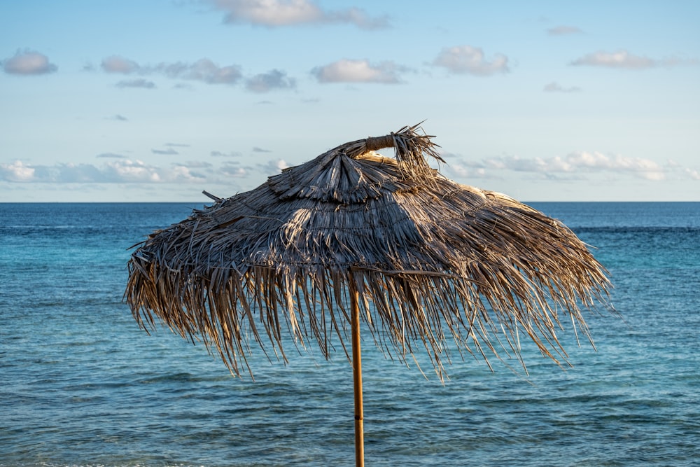 a straw umbrella sitting on top of a sandy beach