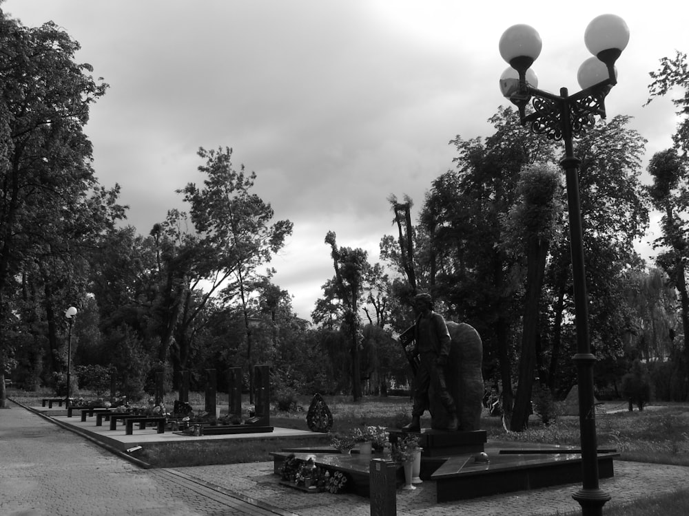 a black and white photo of a statue in a park