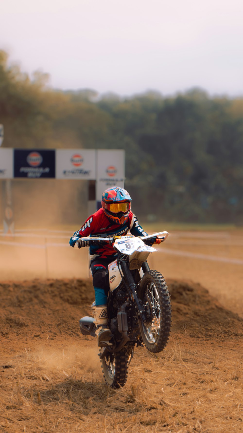 a man riding a dirt bike on top of a dirt field