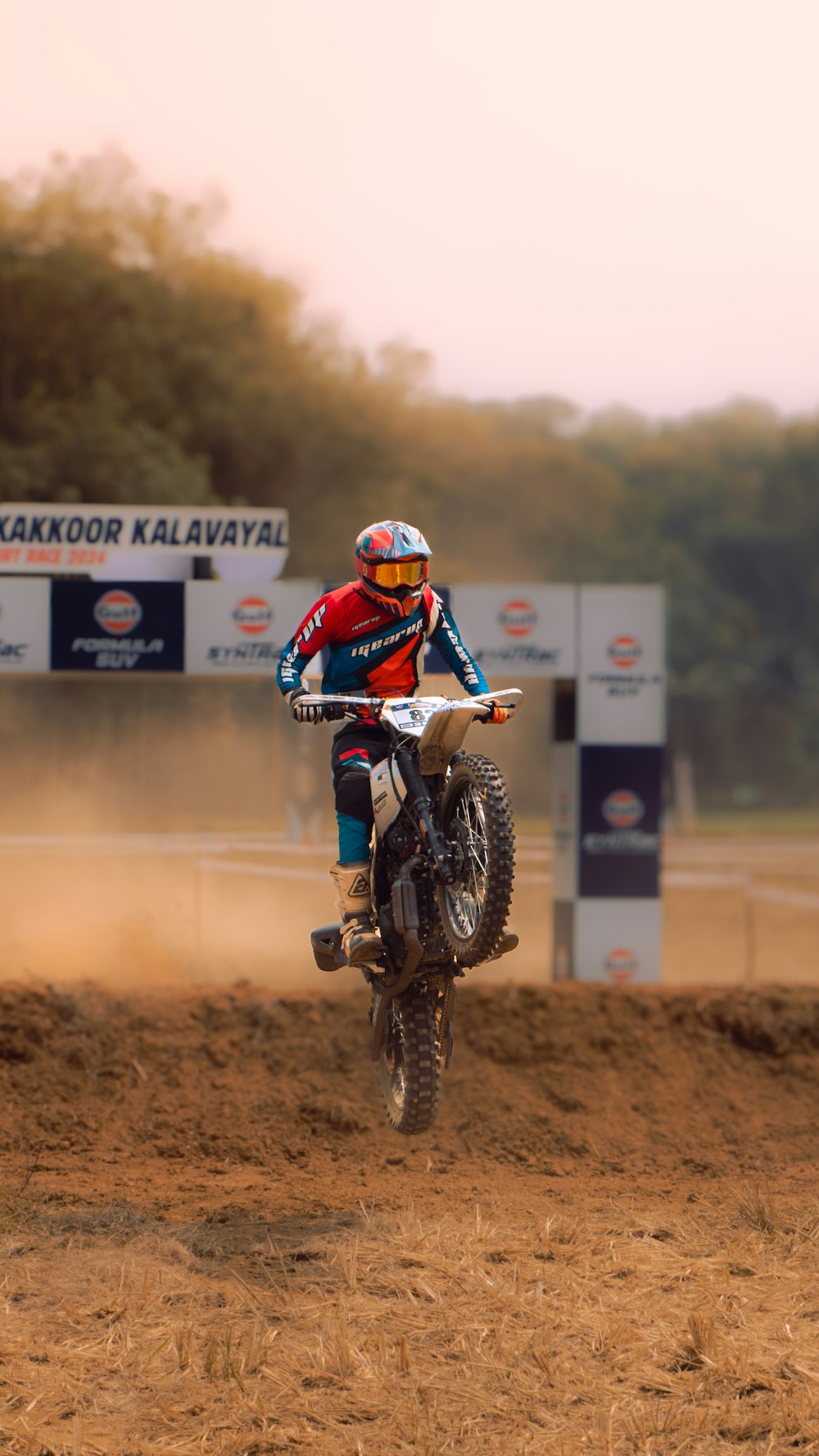 a man riding a dirt bike on top of a dirt field