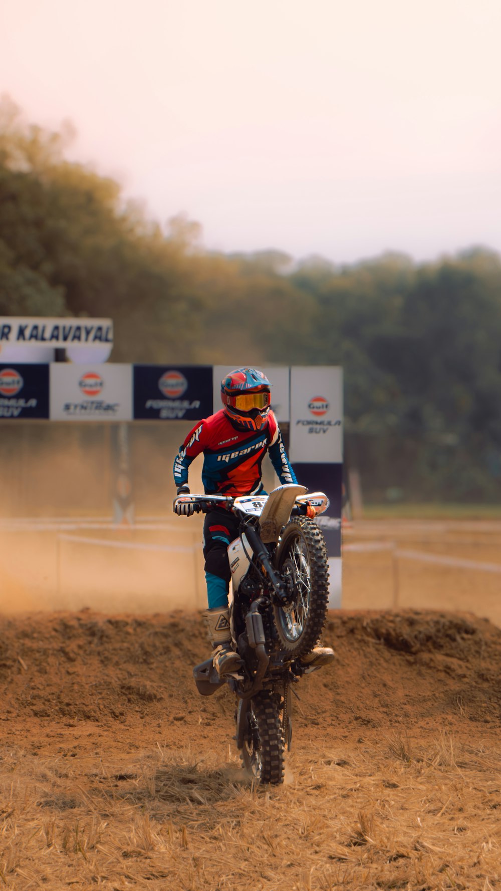 a man riding a dirt bike on top of a dirt field