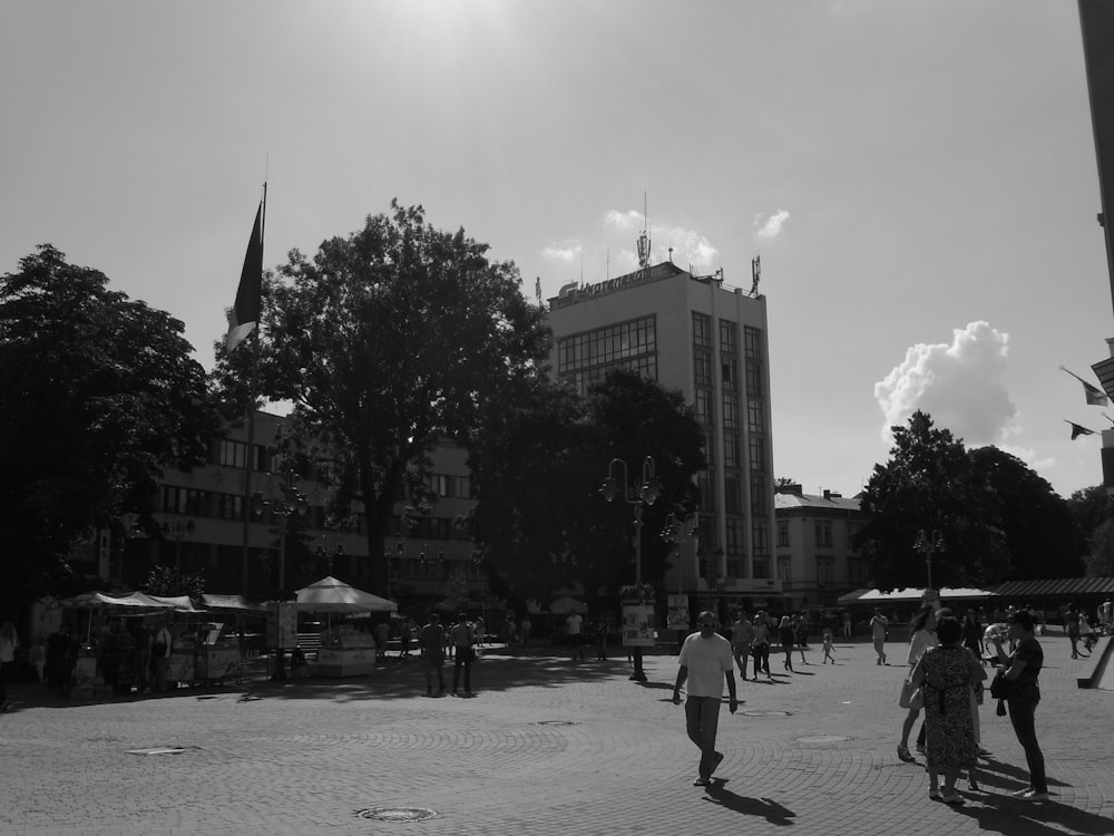 a black and white photo of people walking around