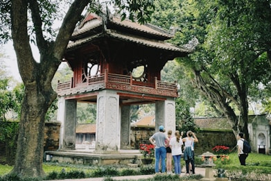 a group of people standing in front of a pagoda