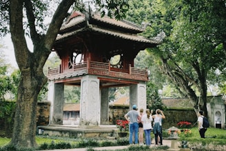 a group of people standing in front of a pagoda