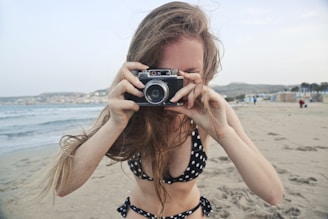 a woman taking a picture of herself on the beach