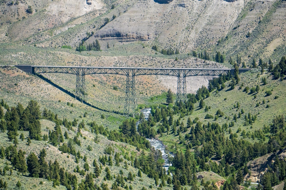 a bridge over a river surrounded by mountains