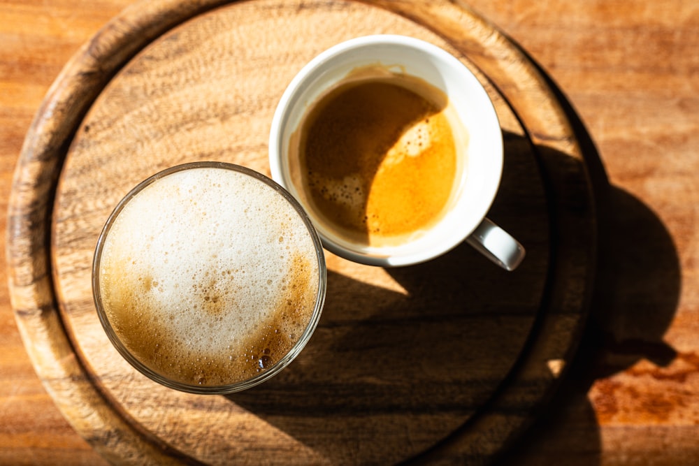 a cup of coffee sitting on top of a wooden table